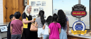Staff of Tulare County Museum catering to a group of children inside the museum.