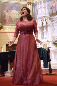 Cristina Fontanelli singing on stage in a red gown  in Southampton NY