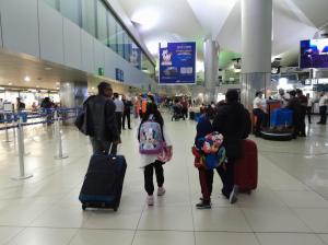 Family arriving in an American airport traveling with suitcases through terminals