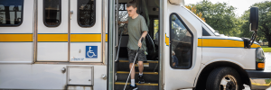 A disabled man riding-off a bus.