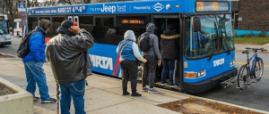 Passengers lining up to ride a bus.
