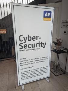 Plakat mit dem Logo von AV-Comparatives und einer Definition von Cybersicherheit.