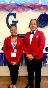 Two students smiling in professional attire.