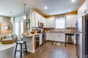 ShoreView Apartments Apartment Amenities showcasing wine fridge, quartz countertops, stainless steel appliances, and glass top stove