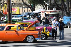 Colorful classic cars on display with people checking them out.