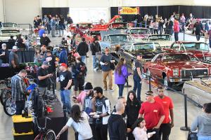 People strolling through the indoor car show.