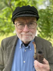 Author Daniel Boyd: Man with white beard, Greek sailor hat, and glasses in sports jacket holding a pipe