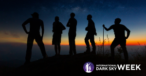 alt= Group of people silhouetted against a sunset and starry sky, observing the night during international dark sky week.