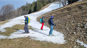 skiers on the slope with limited snow