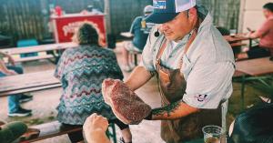 Instructor demonstrating proper trimming technique for a smoked brisket.
