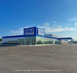 Picture of a blue metal and glass building featuring a Hale Trailer Brake and Wheel logo in an asphalt parking lot