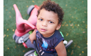 Toddler at Cuidando Los Niños working on his physical development skills during playtime