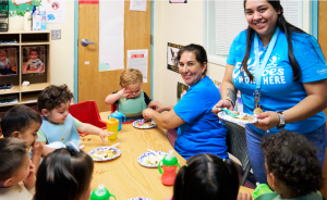 Teachers at Cuidando Los Niños feeding infants 6 weeks-1 year old.