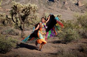 A Native American woman performs a fancy dance with her shawl extended