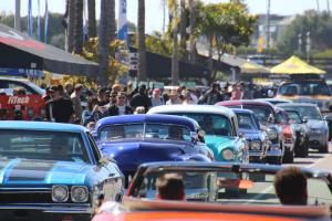 A huge line of classic cars rolling through the Del Mar Fairgrounds.