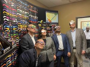 American Paper Optics (L to R CMO Jason Lewin, CEO John Jerit) wearing their eclipse glasses during tour with SBA Administrator Isabel Casillas Guzman (center) and Chirag Parikh, National Space Council executive secretary (center right).