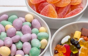 Gummy and chocolate candy in bowls.