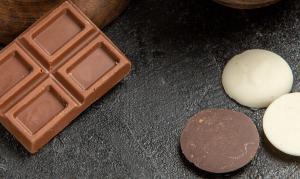 Chocolate bar next to circular pieces of chocolate.