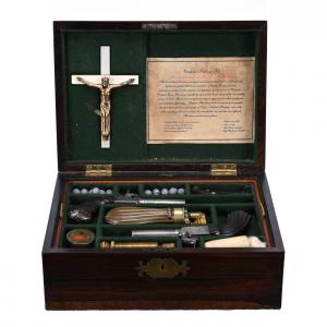 Authentic vampire killing kit, housed in a silk-lined walnut case and featuring an ebony handled dueling pistol, "silver" bullets, a wooden stake, a Crucifix and Holy Water (est. $4,000-$7,000).