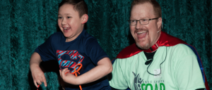 A smiling man wearing spectacles beside a young smiling boy.