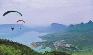 Tourists enjoy paragliding at a scenic area in southwest China’s Guizhou Province
