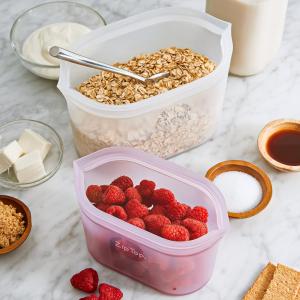 Two Zip Top silicone dishes on the breakfast table, one filled with oats and the other with raspberries.