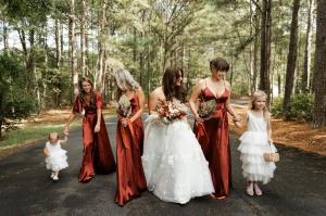 Bridesmaids and bride walking through the paved area in the forest at Evergreen venue.