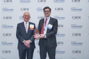 Dr. Harry Selker, Chair of Clinical Research Award, presents the Herbert Pardes Clinical Research Excellence Award statuette to Dr. James LaBelle.