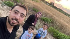 A loving family of four, standing together, showcasing the bond and joy within the Barzaq family