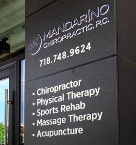 An illuminated sign at the Mandarino Chiropractic office in Bay Ridge, Brooklyn, N.Y., displays a variety of the professional services offered to patients at the site.