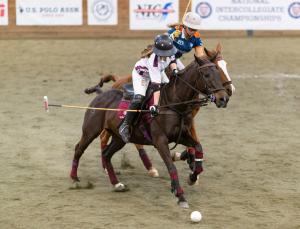 two female arena polo players ride after polo ball