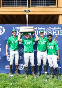 four UNT Men's team arena polo players hold up trophy