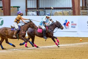 Two polo players ride after ball during play