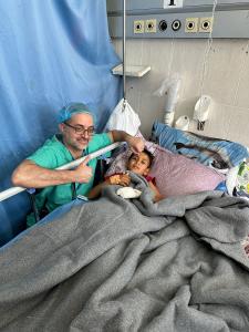 An IMANA doctor at the bedside of a young male patient.