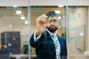 Anish Dhanjee writes his ideas for EqualSeat on a white board