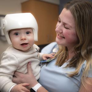 Shriners Children's nurse holding baby.