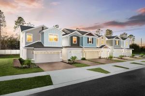 Digital rendering of a modern buildings with a pitched roofs, featuring a sunset and landscaping.