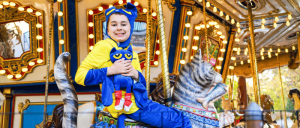 A young boy happily riding a carousel.