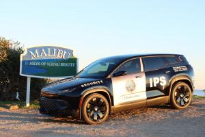 A security vehicle from International Protective Service, Inc. (IPS) stationed by the iconic Malibu sign, underscoring the enhanced safety measures at the upcoming Malibu Moves event. This image captures the essence of both security and scenic beauty, key