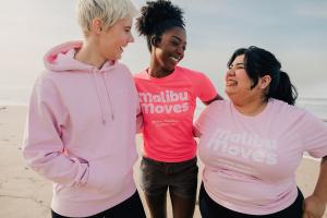 Participants in vibrant Malibu Moves apparel share a joyful moment on the beach, embodying the community spirit and inclusivity of the annual Malibu Moves: 5K, Half Marathon & Kids Run. This image highlights the diverse participants and the friendly atmos