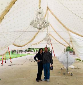 Susan and Jim pose underneath the construction of the 50 x 100-foot Victorian custom made tent for their wedding.