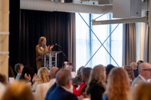 Woman clapping at a large event