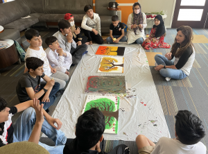 The Black Feather Foundation fosters a sense of teamwork as Afghan refugee children showcase their newly created artwork, discussing the importance of collaboration, leadership, and the challenges and joys of life in the USA.