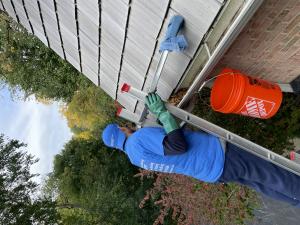 man cleaning gutters