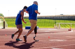 Adaptive athlete and coach running on track