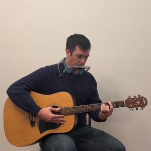 Joe Stevens strumming acoustic guitar