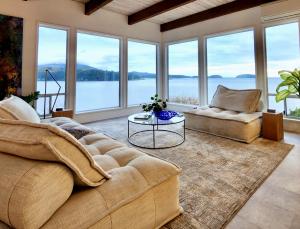 A living room with a stunning n view on a lake, British Columbia's Sunshine Coast, listed on People Like Us