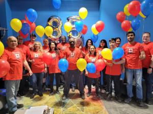Image of a group of KBC team members in red t-shirts with balloons