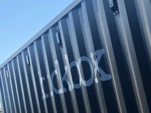 abstract view of a black ISO shipping container with the word kickbox on the side in silver