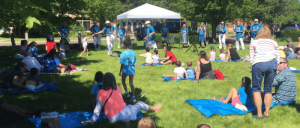 Several individuals enjoying a picnic on the grass in the park.